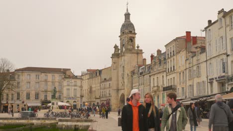 Shot-of-tourists-walking-around-the-city-centre-of-La-rochelle,-a-seaport-on-the-Atlantic-coast-in-western-France-on-a-cloudy-day