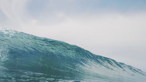 Glistening-ocean-water-from-sunlight-crashes-into-clear-barrel-with-perfect-clarity