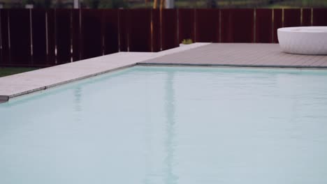 Ruhiges-Ambiente-Am-Pool,-Der-Himmel-Spiegelt-Sich-Im-Wasser,-Umrahmt-Von-Einem-Eleganten-Design
