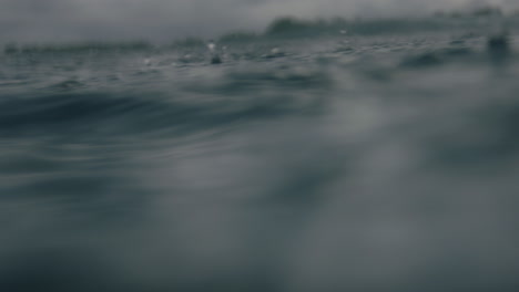 Macro-closeup-of-rain-droplets-on-ocean-water-surface-as-waves-crash