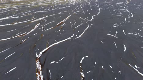 Aerial-Closeup-above-volcanic-soil,-texture-earth-formations-Iceland-black-earth