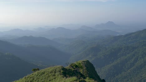 Slow-motion-SLR-scenic-landscape-rolling-hills-forest-mountain-range-cliffs-on-horizon-cloudy-in-Little-Adam`s-Peak-hiking-trail-Ella-Kandy-Sri-Lanka-Asia