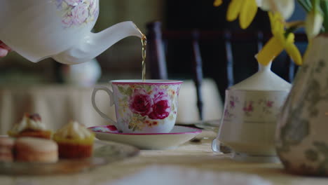 Schwenk-über-Den-Tisch,-Während-Die-Teetasse-Mit-Tee-Gefüllt-Wird