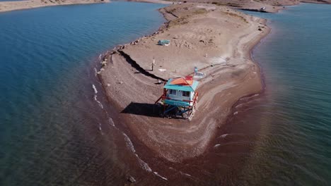 Aerial-orbits-water-rescue-shack-on-peninsula-shore-of-hydro-reservoir