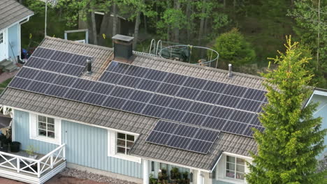 Photovoltaikmodule-Auf-Einem-Dach-Eines-Hauses,-Sonniger-Tag---Telezoom,-Drohnenaufnahme