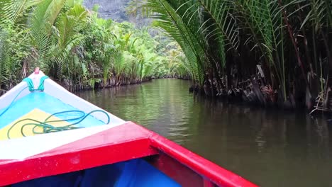 Traditional-boats-cruise-over-a-river-visiting-geological-sites-in-Ramang-Ramang-village,-Maros,-South-Sulawesi,-Indonesia