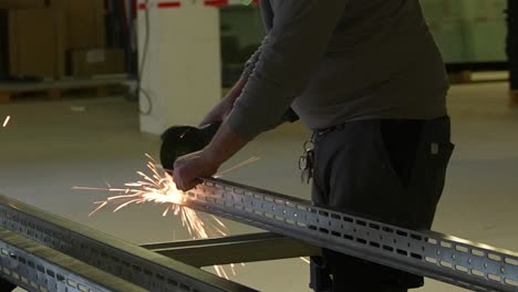 Worker-man-cuts-industry-steel-beams-using-cutting-disc-angle-grinder