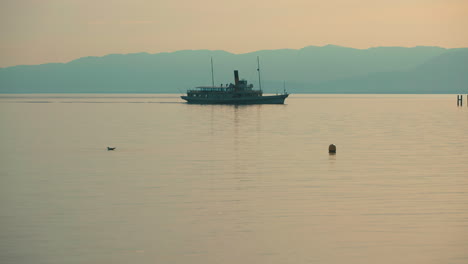 Silhouette-of-ferry-in-Lake-Geneve-during-sunset-between-France-and-Switzerland