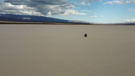 Motorcyclist-rides-across-sand-flat-Pampe-del-leoncito-in-Argentina