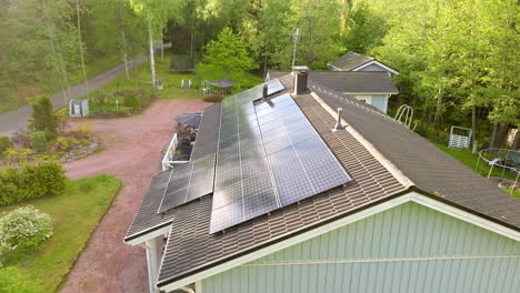 Reflektierende-Solarmodule-Auf-Einem-Modernen-Hausdach,-Sonniger-Sommertag---Drohnenaufnahme