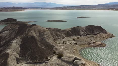 Aerial-flyover-of-rugged-shoreline-of-Potrerillos-hydro-dam-reservoir