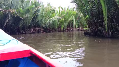 Traditional-boats-cruise-over-a-murky-river-visiting-geological-sites-in-Ramang-Ramang-village,-Maros,-South-Sulawesi,-Indonesia