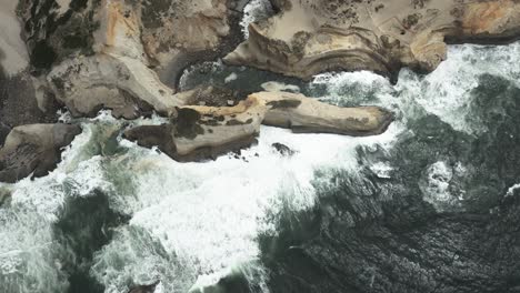 Cape-Kiwanda-with-dark-ocean-waves-crashing,-Pacific-City-Beach,-Oregon,-USA