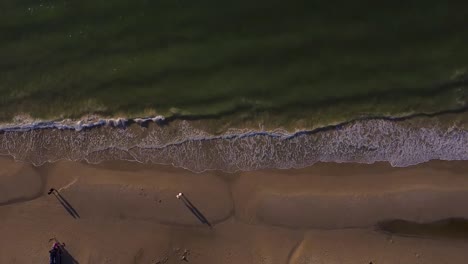 Top-down-drone-shot-of-the-sea-by-a-beach-in-denmark