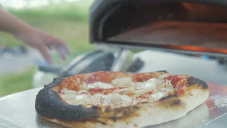 Removing-freshly-baked-pizza-from-outdoor-oven