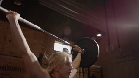 Slomo-of-blonde-woman-showing-good-form-during-snatch-weightlifting-move-in-gym