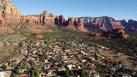 Aerial-View-of-Residential-Neighborhood-in-Sedona,-Arizona-USA,-Houses-in-Valley-Under-Red-Rock-Cliffs