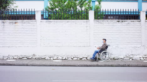 long-shot-of-elderly-man-in-wheelchair-alone