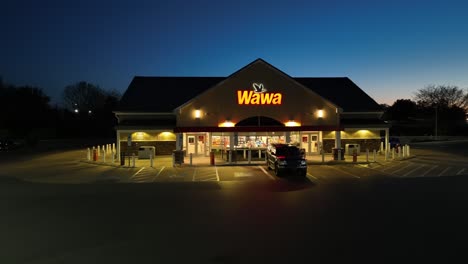 Aerial-approaching-shot-of-WAWA-Gas-Station-and-Convenience-Shop-in-USA-at-night