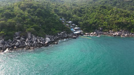 Luxury-resort-villas-on-tropical-island-with-look-over-ocean---drone-view