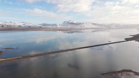 Reflektierte-Wolken,-Isländische-Wasserlandschaft,-Vulkanische-Schneebedeckte-Berge,-Drohnenaufnahme