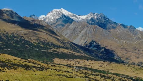 Vibrant-green-lush-landscape-of-Glenorchy-mountains-with-cloud-shadows-and-snow