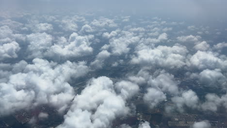 An-aerial-view-of-the-clouds-and-cityscape-below-the-clouds