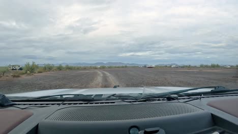 Rain-and-Camping-in-the-Desert---POV-driving-on-gravel-trail-through-groups-of-dispersed-campers-in-the-Sonoran-desert-on-a-rainy-day
