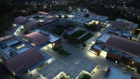 Junior-High-school-in-suburban-neighborhood-at-nighttime---aerial-flyover