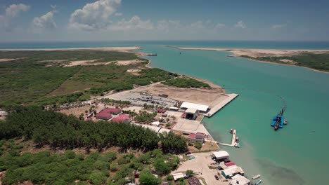 Aerial-view-of-a-sand-plant-in-Matamoros,-Mexico,-with-the-beautiful-Gulf-of-Mexico-sea-in-the-background