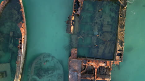 Drone-Tops-Down-Closeup-Oxidized-Ship-Shipwreck-abandoned-at-blue-ocean,-rusted-vehicle