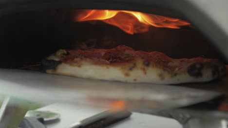 Gebackene-Pizza-Mit-Schinken,-Käse-Und-Pesto-Aus-Dem-Ofen-Nehmen