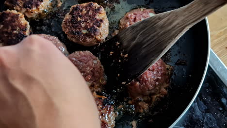 Searing-meatballs-in-a-frying-pan-on-the-stove---isolated-close-up