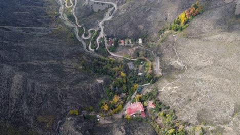 Vista-Aérea-De-Los-árboles-De-Otoño-En-La-Retorcida-Carretera-De-Paso-De-Montaña,-Argentina