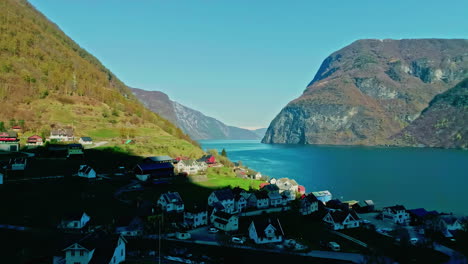 Norway-fjord-shadow-over-village,-aerial-shore-of-Gryllefjord-rural-view