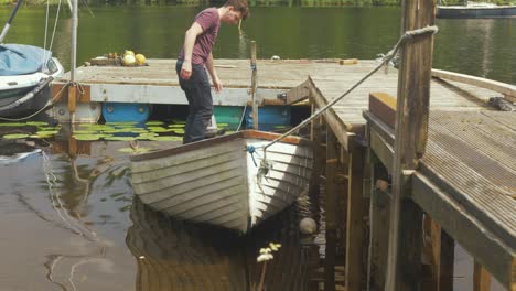 Young-man-bailing-water-from-a-fiberglass-row-boat