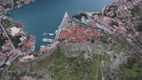4K-Drohnenaufnahmen-Zeigen-Die-Festung-Von-Kotor-Sowie-Die-Zum-UNESCO-Weltkulturerbe-Gehörende-Altstadt-Und-Den-Hafen-In-Der-Bucht-Von-Kotor,-Montenegro