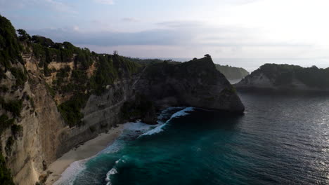 Diamond-beach-at-foot-of-sheer-limestone-sea-cliffs,-Nusa-Penida