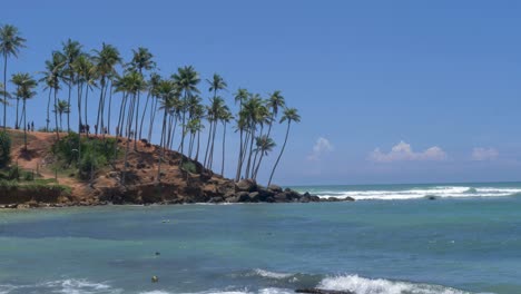 Zeitlupen-SLR-Landschaftsansicht-Einer-Palmenplantage-Auf-Einem-Kokosnussbaumhügel-Mit-Meereswellen-Am-Strand,-Tourismusort-Mirissa-Bay-Point,-Weligama,-Sri-Lanka