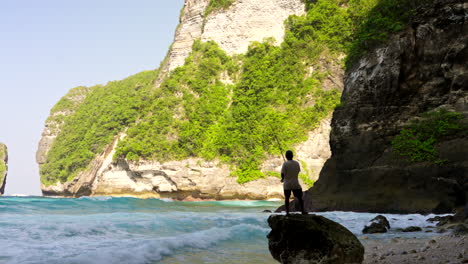 Lone-native-fisherman-casting,-limestone-rocks,-ocean-water,-coastline