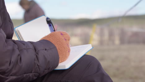 Woman-writes-in-journal-to-process-feelings-during-equine-facilitated-workshop