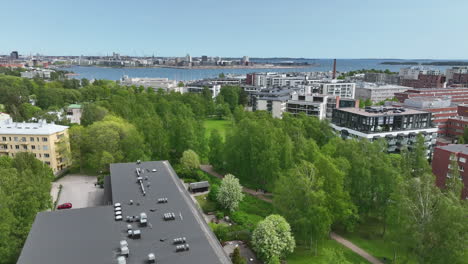 Aerial-view-around-spring-colored-trees-in-a-park,-in-sunny-Lauttasaari,-Helsinki