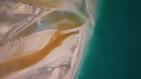 Aerial-top-down-descending-on-glacial-floodplain-delta-with-orange-sandy-deposits