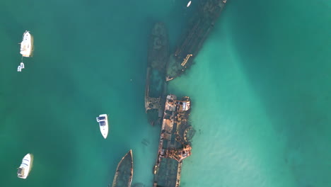 Blue-Sea-Aerial-Top-Down-Shipwreck-Oxidized-Ship-Vehicle-in-Pristine-Water-Drone-Shot