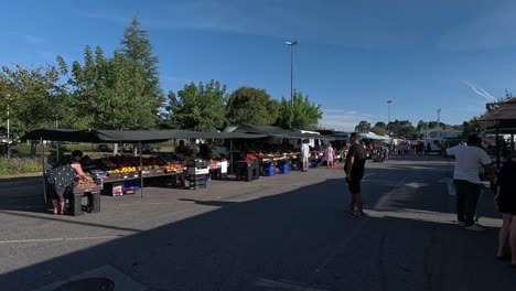 Street-fruit-and-vegetable-shops,-people-come-to-buy-groceries-in-the-morning-at-dawn-on-a-sunny-and-warm-summer-day,-shot-turning-right