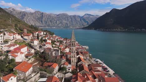 4K-drone-footage-captures-Saint-Nicholas-Church-in-the-charming-town-of-Perast,-Montenegro,-with-a-beautiful-view-of-the-UNESCO-listed-turquoise-Bay-of-Kotor-and-mountains-in-the-background