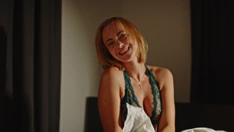 Portrait-of-a-beautiful-woman-in-lingerie-joyfully-playing-with-a-white-pillow-and-smiling-at-camera-in-slow-motion