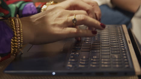 Eine-Nahaufnahme-Gut-Geschmückter-Weiblicher-Hände,-Die-Auf-Einer-Laptoptastatur-Tippen