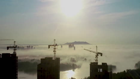 Construction-Work-On-The-Tower-Crane-Machine-To-Built-Tall-Tower-Property-Building-Workplace-Day-And-Clouds-Flowing-Over-City,-The-Mountains-In-Sunset