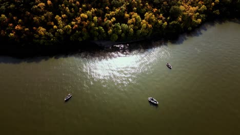 A-Static-Drone-Shot-of-Three-Small-Boats-Anchored-Off-a-Forest-Embankment